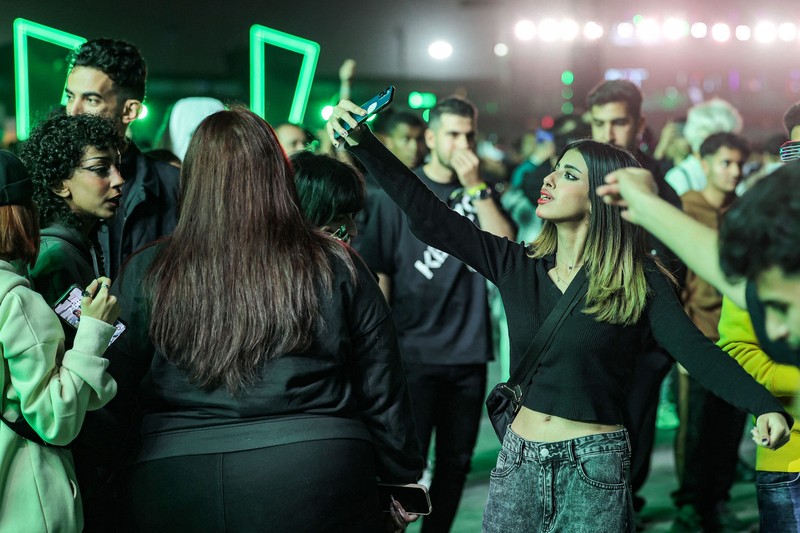 Perempuan Arab Saudi Menonton Konser Penonton menari selama festival musik MDLBEAST Soundstorm 2022 di Banban di pinggiran utara ibu kota Arab Saudi, Riyadh, Kamis (1/12/2022). (Photo by FAYEZ NURELDINE/AFP via Getty Images)