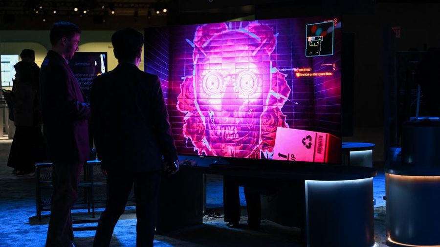 Attendees view a video game on a Samsung Electronics Co. Gaming Hub enabled smart TV that does not require a video game console displayed during a media preview ahead of the Consumer Electronics Show (CES) of Las Vegas, Nevada on January 3, 2023. - CES explores next-gen technology in the context of numerous topics, including 5G and IoT, advertising, automotive, block chain, health and wellness, immersive entertainment, robotics and more. 2023 CES will showcase more than 1400 exhibiting companies. (Photo by Patrick T. Fallon / AFP)
