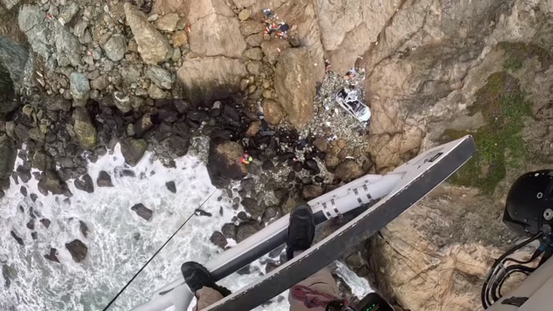 Kecelakaan mobil listrik tesla model y di Devil's Slide, daerah San Mateo, California, AS Seorang korban kecelakaan diangkat ke helikopter selama operasi penyelamatan setelah sebuah kendaraan yang membawa dua orang dewasa dan dua anak melewati tebing terjun ratusan kaki di Devil's Slide, daerah San Mateo, California, AS, Senin (2/1/2023). Empat orang penumpang mobil listrik Tesla Model Y selamat setelah mobil tersebut terjun bebas dari tebing yang dinamakan Turunan Setan atau Devil Slide di Amerika Serikat. (Facebook/CHP - Golden Gate Division Air Operations via REUTERS)