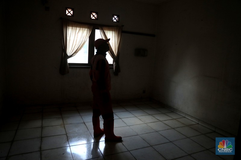 Petugas PPSU menebang pohon di depan rumah mewah terbengkalai yang viral di media sosial di Kawasan Jatinegara, Cakung, Jakarta, Kamis, (5/1/2023). (CNBC Indonesia/ Muhammad Sabki)