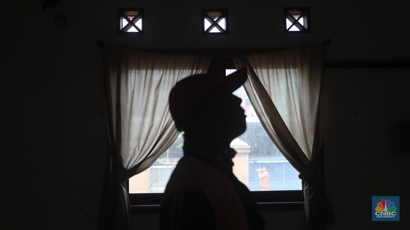 Petugas PPSU menebang pohon di depan rumah mewah terbengkalai yang viral di media sosial di Kawasan Jatinegara, Cakung, Jakarta, Kamis, (5/1/2023). (CNBC Indonesia/ Muhammad Sabki)