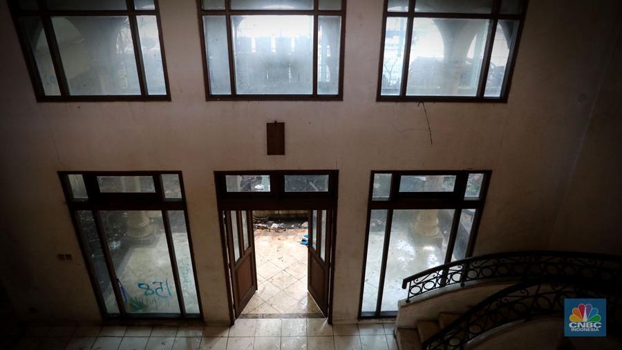 Petugas PPSU menebang pohon di depan rumah mewah terbengkalai yang viral di media sosial di Kawasan Jatinegara, Cakung, Jakarta, Kamis, (5/1/2023). (CNBC Indonesia/ Muhammad Sabki)