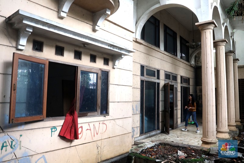 Petugas PPSU menebang pohon di depan rumah mewah terbengkalai yang viral di media sosial di Kawasan Jatinegara, Cakung, Jakarta, Kamis, (5/1/2023). (CNBC Indonesia/ Muhammad Sabki)