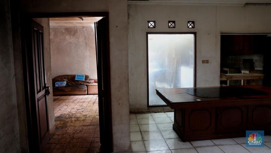 Petugas PPSU menebang pohon di depan rumah mewah terbengkalai yang viral di media sosial di Kawasan Jatinegara, Cakung, Jakarta, Kamis, (5/1/2023). (CNBC Indonesia/ Muhammad Sabki)