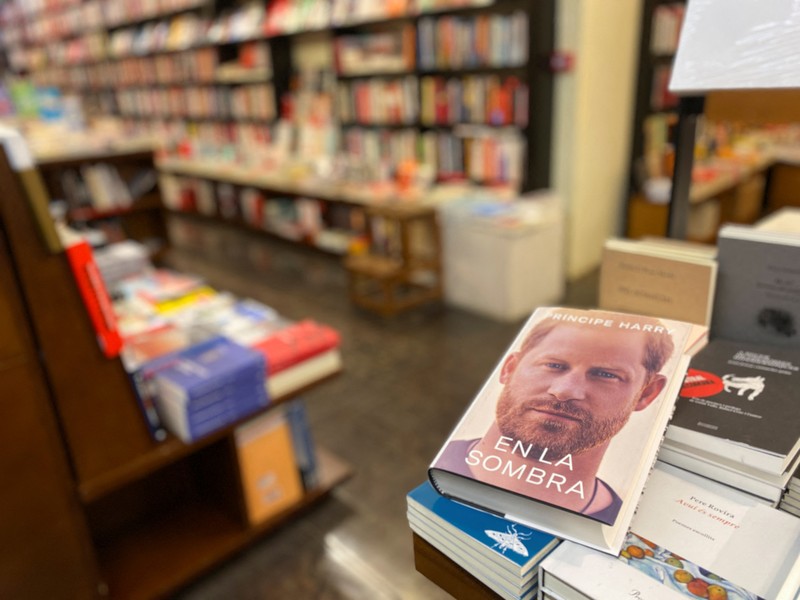 A woman poses for a photo as she opens a copy of 