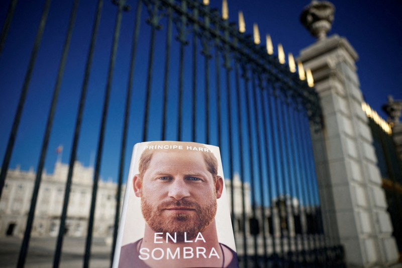 Spain Britain Prince Harry A woman poses for a photo as she opens a copy of