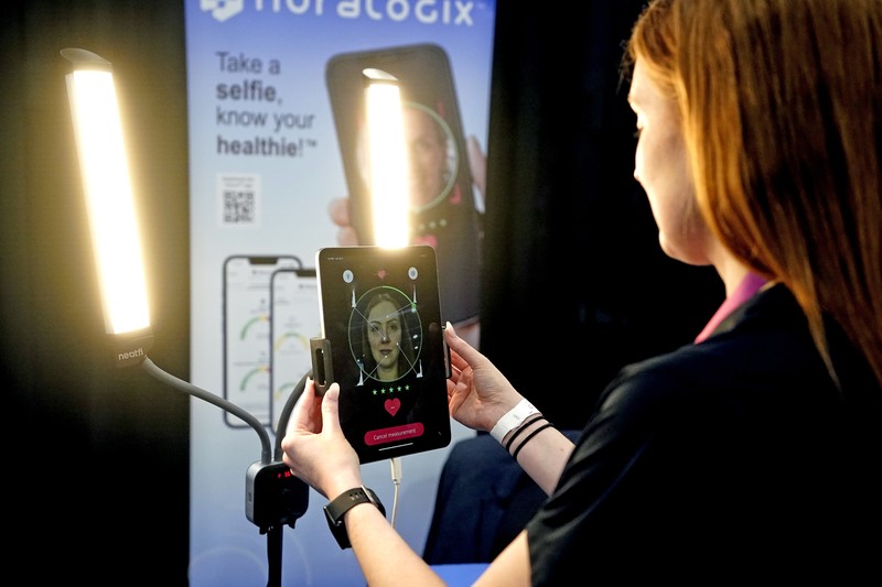 The Anura Lite is demonstrated at the Nuralogix booth during CES Unveiled ahead of the CES tech show, Tuesday, Jan. 3, 2023, in Las Vegas. The application uses a 30-second video selfie to capture facial blood flow patterns, which are used to output medical-grade health and vital sign measurements. (AP Photo/Rick Bowmer)