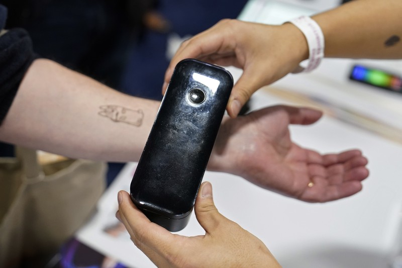 The Anura Lite is demonstrated at the Nuralogix booth during CES Unveiled ahead of the CES tech show, Tuesday, Jan. 3, 2023, in Las Vegas. The application uses a 30-second video selfie to capture facial blood flow patterns, which are used to output medical-grade health and vital sign measurements. (AP Photo/Rick Bowmer)