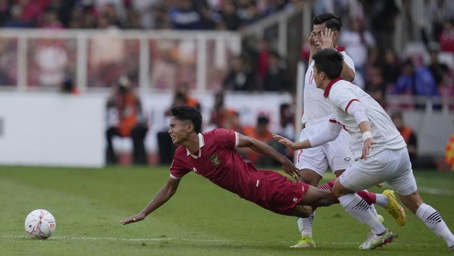 Indonesia's Marselino Ferdinan Philipus, left, is tackled by Vietnam's Nguyen Tuanh Anh, rear right, and Do Duy Manh during their first leg of ASEAN Football Federation (AFF) Cup 2022 semifinal soccer match at Gelora Bung Karno Main Stadium in Jakarta, Indonesia, Friday, Jan. 6, 2023. (AP Photo/Achmad Ibrahim)
