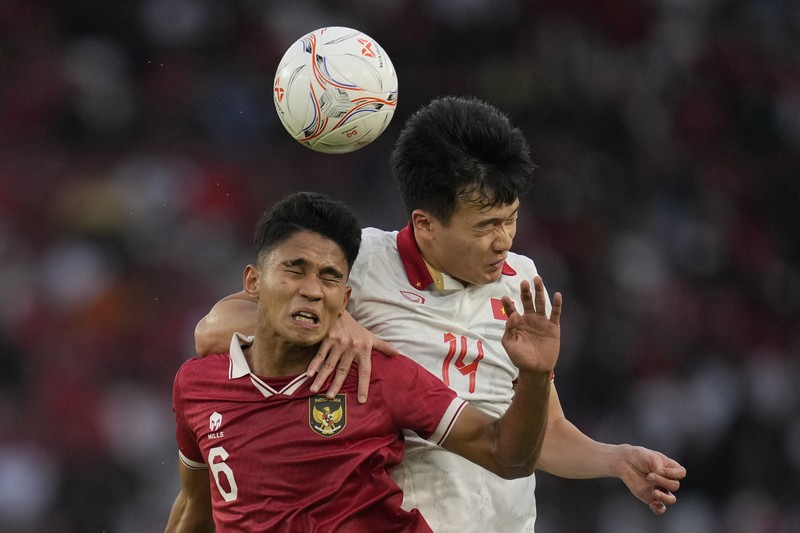 Vietnam's Phan Van Duc, left, battles for the ball against Indonesia's Rachmat Irianto during their first leg of ASEAN Football Federation (AFF) Cup 2022 semifinal soccer match at Gelora Bung Karno Main Stadium in Jakarta, Indonesia, Friday, Jan. 6, 2023. (AP Photo/Achmad Ibrahim)