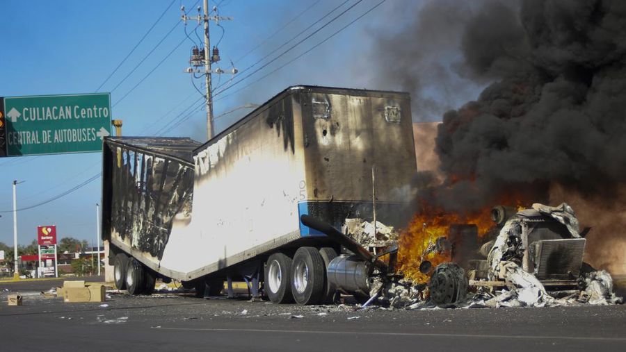 Sebuah truk terbakar di sebuah jalan di Culiacan, negara bagian Sinaloa, Kamis, 5 Januari 2023. Pasukan keamanan Meksiko menangkap Ovidio Guzmán, seorang tersangka pengedar narkoba yang dicari oleh Amerika Serikat dan salah satu putra mantan bos kartel Sinaloa Joaquín “El Chapo ” Guzmán, dalam operasi dini hari Kamis yang memicu baku tembak dan penghalang jalan di seluruh ibu kota negara bagian barat. (AP Photo/Martin Urista)