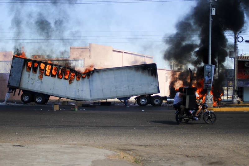 Kendaraan yang terbakar terlihat menghalangi jalan setelah gembong narkoba Ovidio Guzman ditangkap, di Culiacan, Sinaloa, Meksiko 5 Januari 2023. (Revista Espejo/Leo Espinoza/Handout via REUTERS)