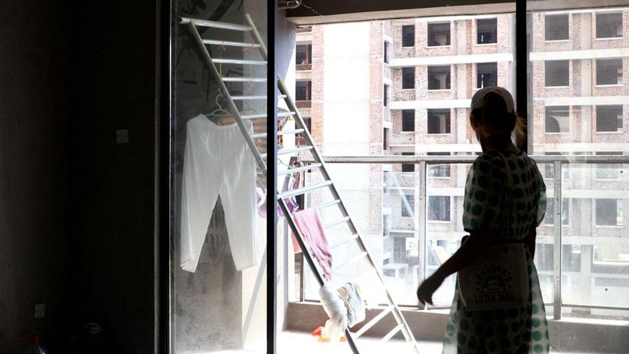 Pembeli rumah Ms. Xu berdiri di apartemennya yang belum selesai di mana dia tinggal, di sebuah kompleks perumahan yang dikembangkan oleh Real Estat Jiadengbao di Guilin, Daerah Otonomi Guangxi Zhuang, Tiongkok, dalam tangkapan layar ini diambil dari rekaman video 17 September 2022. (Dok. File - REUTERS TV/File Photo)