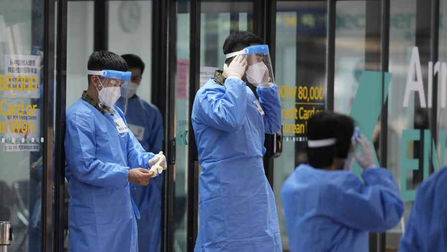 Petugas kesehatan memeriksa alat pelindung mereka di luar pusat pengujian COVID-19 di Bandara Internasional Incheon di Incheon, Korea Selatan, Kamis, 5 Januari 2023. (AP Photo/Lee Jin-man)