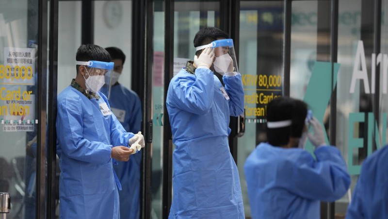 Petugas kesehatan memeriksa alat pelindung mereka di luar pusat pengujian COVID-19 di Bandara Internasional Incheon di Incheon, Korea Selatan, Kamis, 5 Januari 2023. (AP Photo/Lee Jin-man)