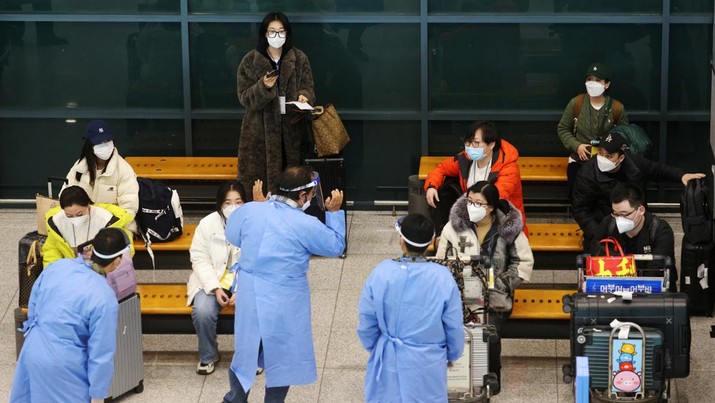 Sekelompok turis Tiongkok dipimpin oleh tentara Korea Selatan yang mengenakan alat pelindung diri (APD) saat mereka menunggu tes penyakit virus corona (COVID-19) setibanya di Bandara Internasional Incheon di Incheon, Korea Selatan, 4 Januari 2023. (REUTERS/Kim Hong-Ji)