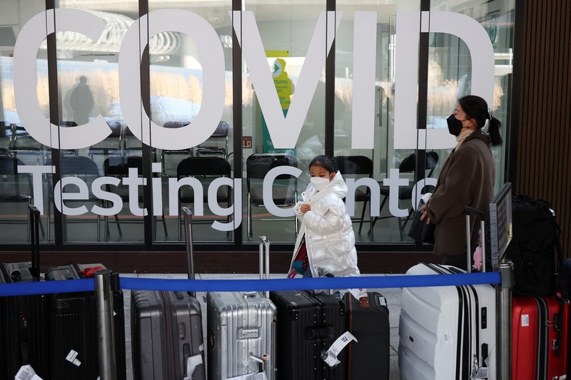 Petugas kesehatan memeriksa alat pelindung mereka di luar pusat pengujian COVID-19 di Bandara Internasional Incheon di Incheon, Korea Selatan, Kamis, 5 Januari 2023. (AP Photo/Lee Jin-man)