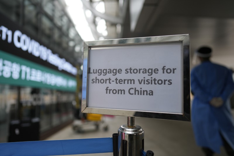 Petugas kesehatan memeriksa alat pelindung mereka di luar pusat pengujian COVID-19 di Bandara Internasional Incheon di Incheon, Korea Selatan, Kamis, 5 Januari 2023. (AP Photo/Lee Jin-man)