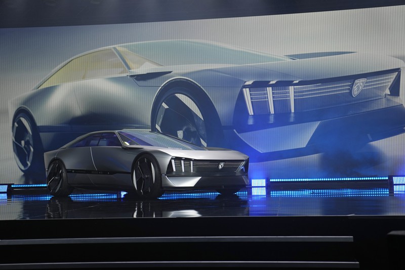 Stella Clark of BMW AG, shows off the BMW i Vision Dee concept car that changes color during a pre-show keynote at CES 2023 Wednesday, Jan. 4, 2023, in Las Vegas. (AP Photo/Jack Dempsey)