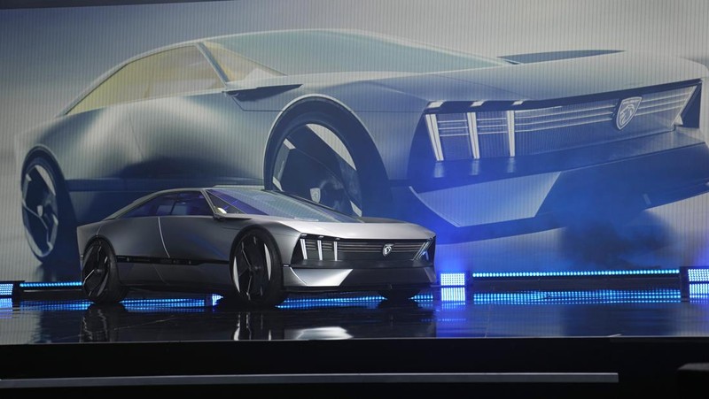 Stella Clark of BMW AG, shows off the BMW i Vision Dee concept car that changes color during a pre-show keynote at CES 2023 Wednesday, Jan. 4, 2023, in Las Vegas. (AP Photo/Jack Dempsey)