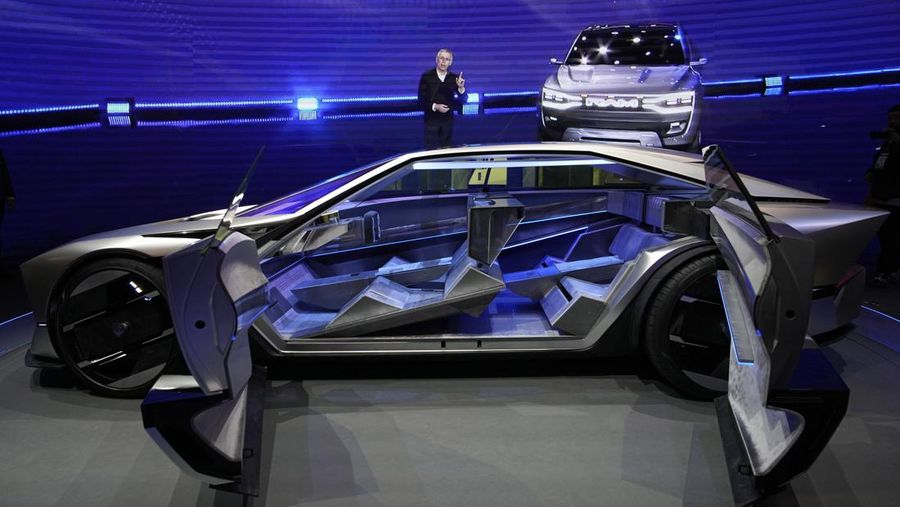 Stella Clark of BMW AG, shows off the BMW i Vision Dee concept car that changes color during a pre-show keynote at CES 2023 Wednesday, Jan. 4, 2023, in Las Vegas. (AP Photo/Jack Dempsey)