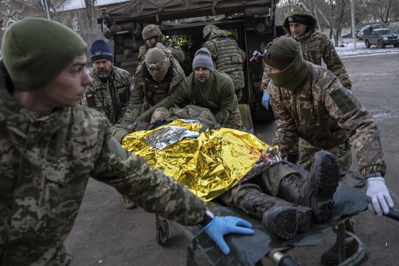 APTOPIX Russia Ukraine War Ukrainian military medics carry a body of their killed comrade into a morgue in Donetsk region, Ukraine, Monday, Jan. 9, 2023. (AP Photo/Evgeniy Maloletka)
