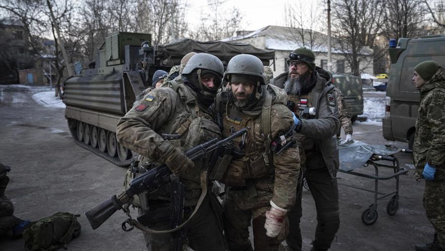 A Ukrainian serviceman carries his injured comrade evacuated from the battlefield into a hospital in Donetsk region, Ukraine, Monday, Jan. 9, 2023. (AP Photo/Evgeniy Maloletka)