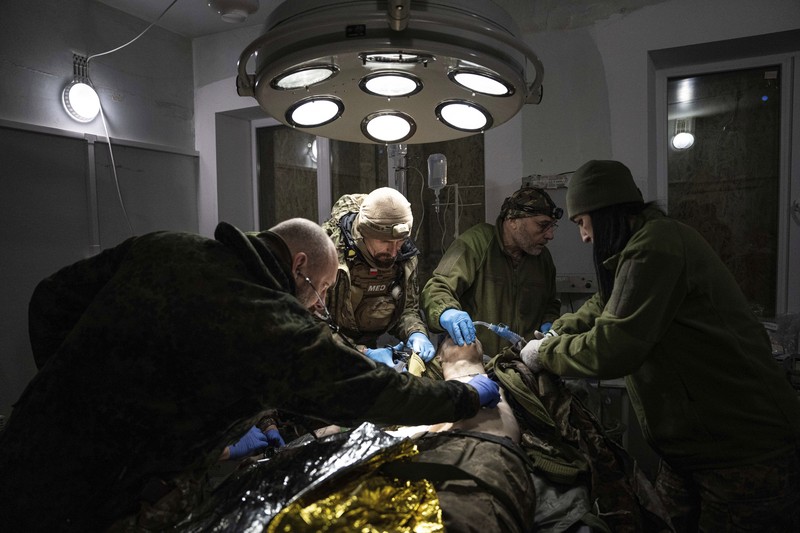 APTOPIX Russia Ukraine War Ukrainian military medics carry a body of their killed comrade into a morgue in Donetsk region, Ukraine, Monday, Jan. 9, 2023. (AP Photo/Evgeniy Maloletka)