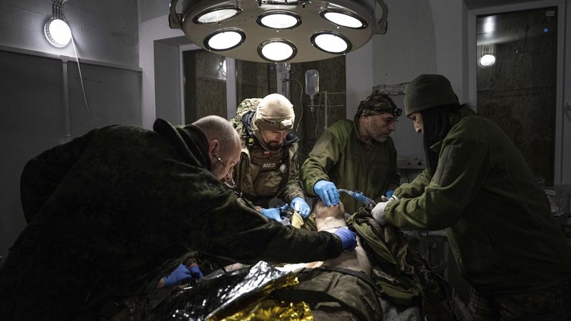 Ukrainian military medics carry a body of their killed comrade into a morgue in Donetsk region, Ukraine, Monday, Jan. 9, 2023. (AP Photo/Evgeniy Maloletka)