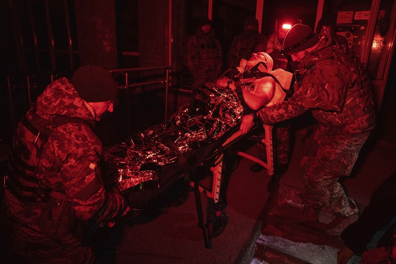Ukrainian military medics carry a body of their killed comrade into a morgue in Donetsk region, Ukraine, Monday, Jan. 9, 2023. (AP Photo/Evgeniy Maloletka)