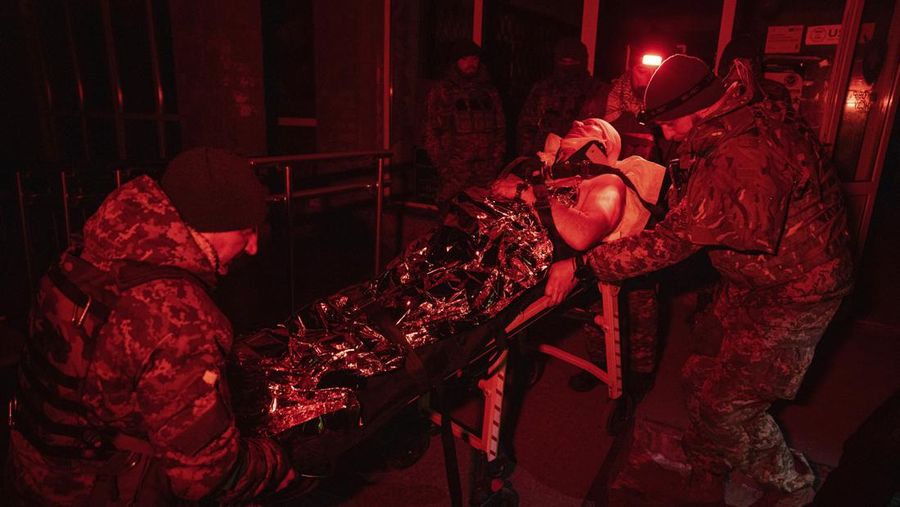 Ukrainian military medics carry a body of their killed comrade into a morgue in Donetsk region, Ukraine, Monday, Jan. 9, 2023. (AP Photo/Evgeniy Maloletka)