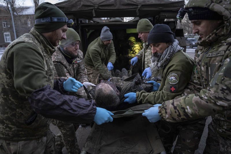 APTOPIX Russia Ukraine War Ukrainian military medics carry a body of their killed comrade into a morgue in Donetsk region, Ukraine, Monday, Jan. 9, 2023. (AP Photo/Evgeniy Maloletka)