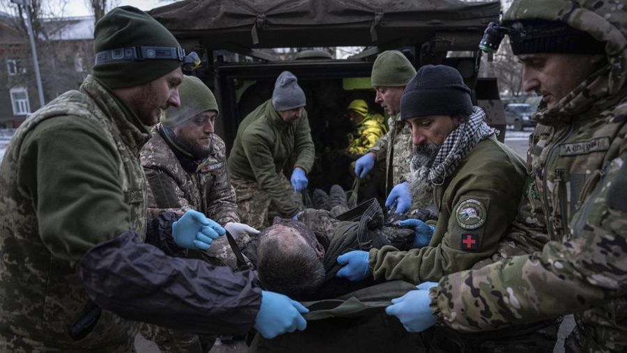 Ukrainian military medics carry an injured Ukrainian serviceman evacuated from the battlefield into a hospital in Donetsk region, Ukraine, Monday, Jan. 9, 2023. A serviceman did not survive. (AP Photo/Evgeniy Maloletka)