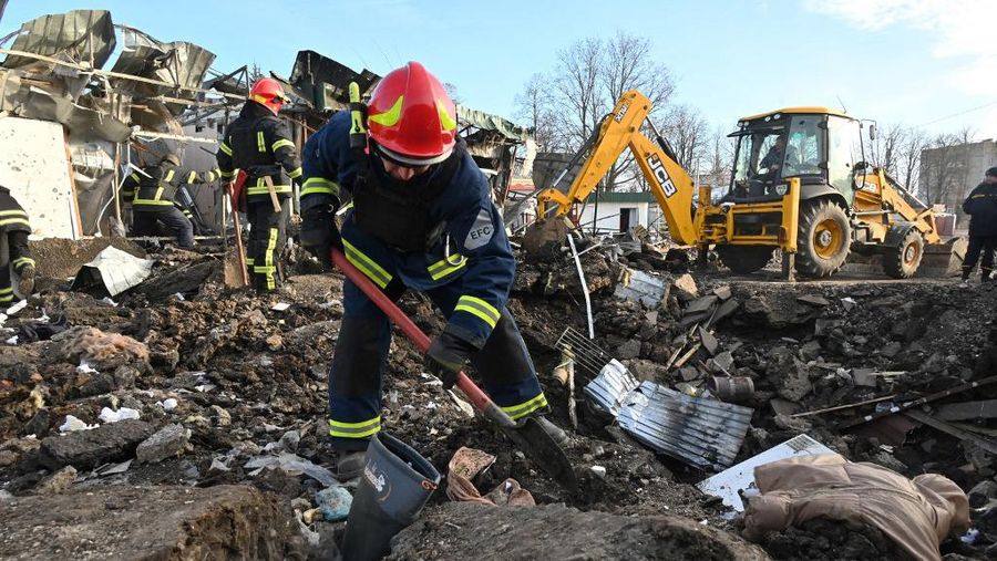 Tim penyelamat Ukraina bekerja di lokasi setelah serangan rudal Rusia di pasar lokal di desa Shevchenkove, wilayah Kharkiv pada 9 Januari 2023. (AFP/SERGEY BOBOK)