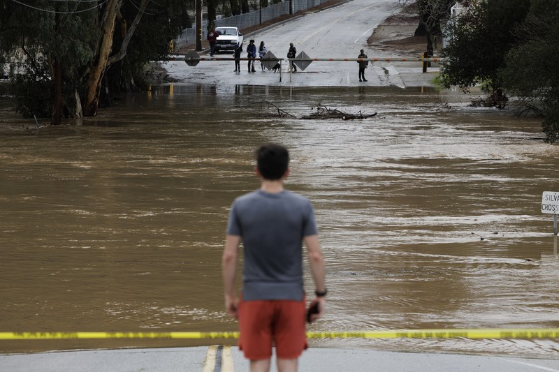 Uvas Creek membanjiri bagian Miller Avenue di Gilroy, California, saat rangkaian terbaru sungai di atmosfer menghantam Bay Area pada Senin, 9 Januari 2023. (Dai Sugano/Bay Area News Group via AP)