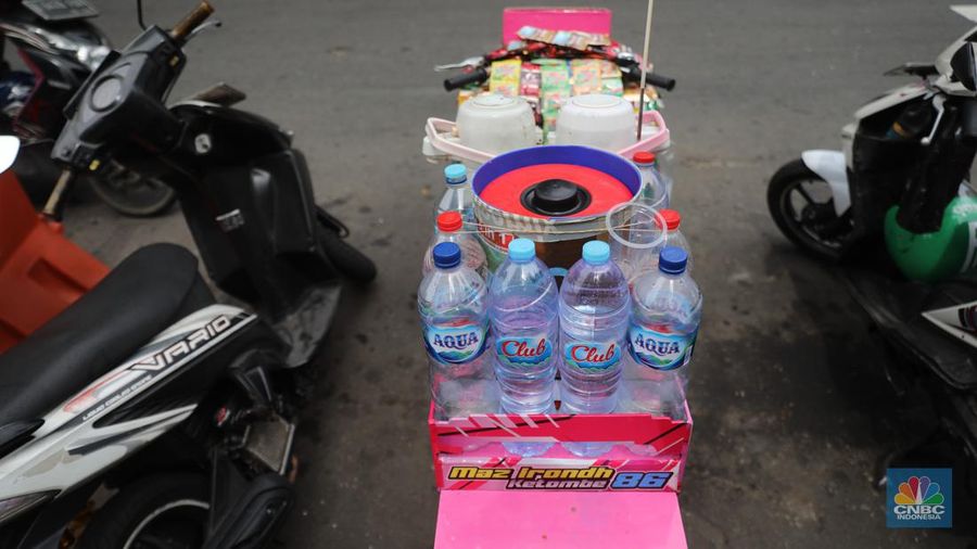 Pedagang kopi keliling menyiapkan minuman di kawasan Pedestrian Sudirman, Jakarta, Rabu, 11/1/2023. Pedagang kopi keliling atau kerap disebut starling sering terluhat hilir mudik setiap hari di jalan-jalan trotoar Jakarta. (CNBC Indonesia/ Muhammad Sabki)