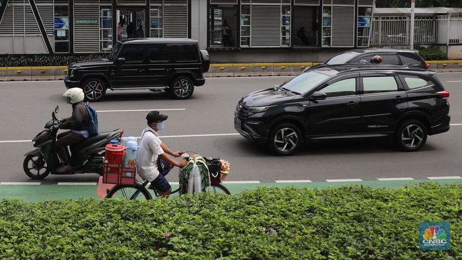 Pedagang kopi keliling menyiapkan minuman di kawasan Pedestrian Sudirman, Jakarta, Rabu, 11/1/2023. Pedagang kopi keliling atau kerap disebut starling sering terluhat hilir mudik setiap hari di jalan-jalan trotoar Jakarta. (CNBC Indonesia/ Muhammad Sabki)