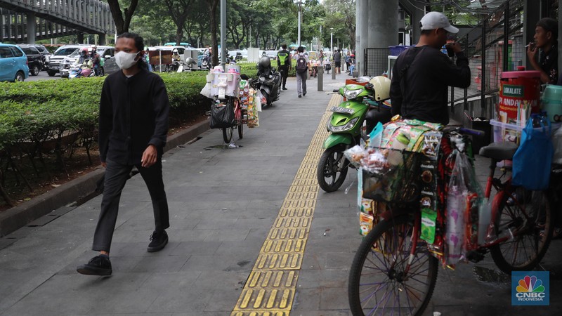 Pedagang kopi keliling menyiapkan minuman di kawasan Pedestrian Sudirman, Jakarta, Rabu, 11/1/2023. Pedagang kopi keliling menyiapkan minuman di kawasan Pedestrian Sudirman, Jakarta, Rabu, 11/1/2023. Pedagang kopi keliling atau kerap disebut starling sering terluhat hilir mudik setiap hari di jalan-jalan trotoar Jakarta. (CNBC Indonesia/ Muhammad Sabki)