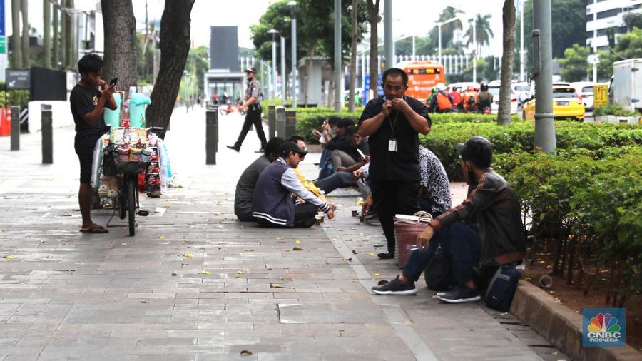 Pedagang kopi keliling menyiapkan minuman di kawasan Pedestrian Sudirman, Jakarta, Rabu, 11/1/2023. Pedagang kopi keliling atau kerap disebut starling sering terluhat hilir mudik setiap hari di jalan-jalan trotoar Jakarta. (CNBC Indonesia/ Muhammad Sabki)