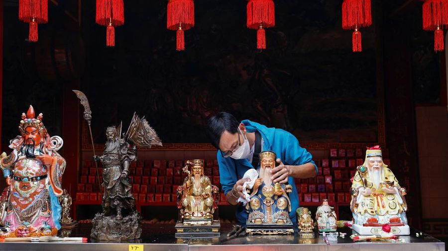 A worshiper cleans sacred figures during Lunar New Year preparations at the Dhanagun temple in Bogor, West Java province, Indonesia, January 16, 2023. REUTERS/Willy Kurniawan