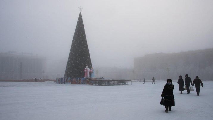TOPSHOT - People walk at the main square of the eastern Siberian city of Yakutsk decorated for the upcoming New Year and Christmas celebrations, with the air temperature at about minus 41 degrees Celsius, on November 30, 2018. - Yakutsk is considered to be the coldest city in the world. (Photo by Mladen ANTONOV / AFP)        (Photo credit should read MLADEN ANTONOV/AFP via Getty Images)