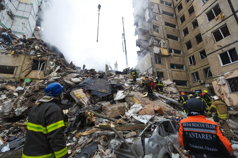 1456795838 DNIPRO, UKRAINE - JANUARY 15: Rescuers search people trapped under the rubble of a high-rise residential building hit by a missile on January 15, 2023 in Dnipro, Ukraine. On January 14, Russia launched a new massive attack on Ukrainian cities. In Dnipro, one of the Х-22 cruise missiles hit a nine-story residential building, completely destroying one of the sections from top to bottom floors. The number of dead has increased to 29 people, with rescue work continuing. More than 40 residents of the building are still being searched. (Photo by Yurii Stefanyak/Global Images Ukraine via Getty Images)