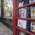 Public telephone box which has faded sex cards tacked up inside in the exclusive area of Mayfair on 2nd December 2022 in London, United Kingdom. These advertising cards for prostitutes are how people advertise for sexual services under the guise of o