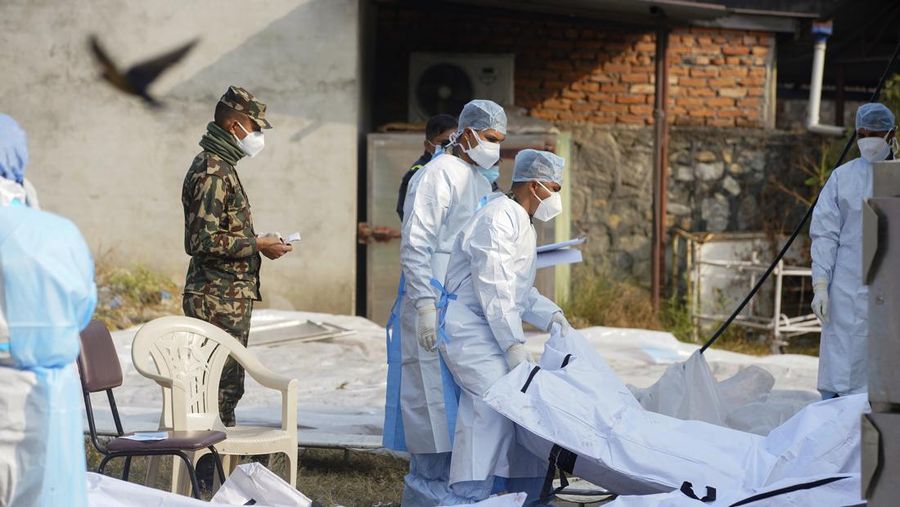 A rescue team recovers the bodies of victims from the site of the plane crash of a Yeti Airlines-operated aircraft, in Pokhara, Nepal January 16, 2023. REUTERS/Sulav Shrestha NO RESALES. NO ARCHIVES  REFILE - CORRECTING THE NUMBER OF BODIES    TPX IMAGES OF THE DAY