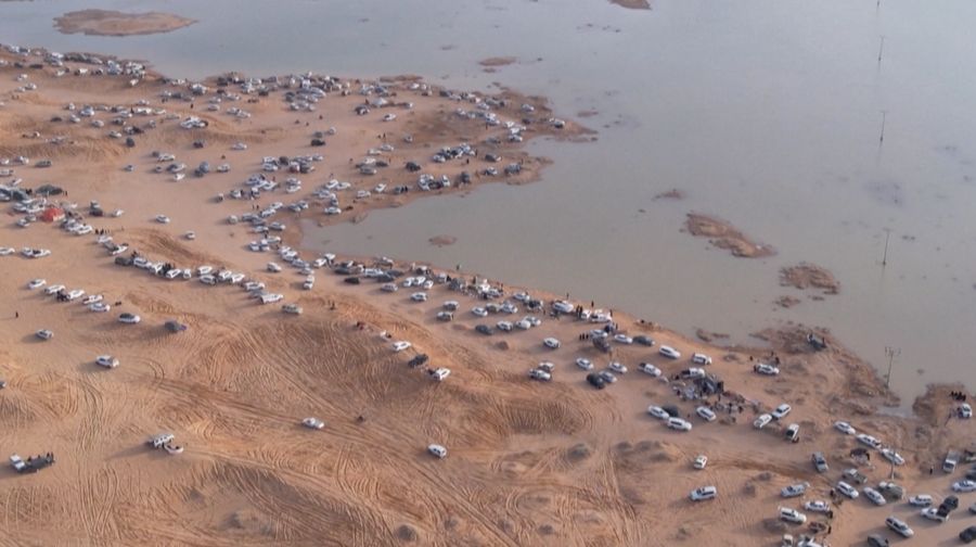 Seorang warga mengambil foto bukit yang menghijau setelah hujan deras di Mekkah, Arab Saudi pada 16 Januari 2023. (Photo by Hani Alshaer/Anadolu Agency via Getty Images)