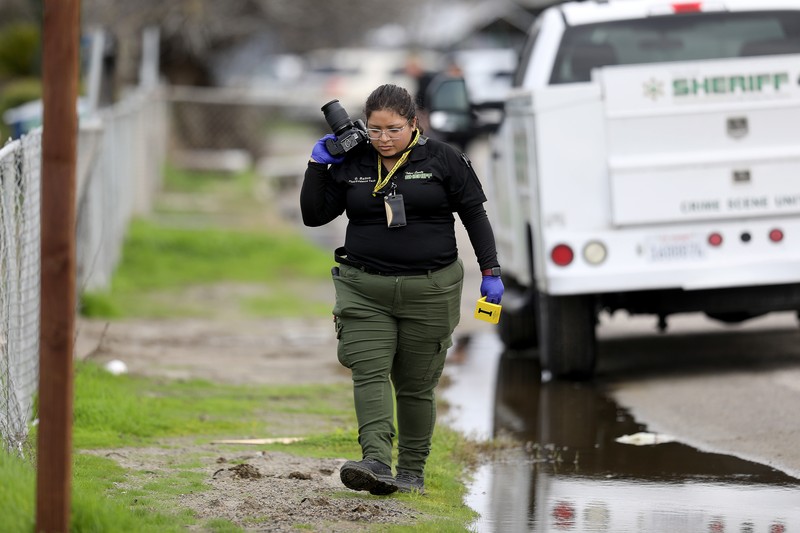 Unit kejahatan Sheriff Kabupaten Tulare menyelidiki tempat kejadian di mana enam orang, termasuk bayi berusia 6 bulan, ibu remajanya dan seorang wanita tua, tewas di komunitas pertanian Central Valley dalam apa yang dikatakan sheriff setempat kemungkinan serangan yang ditargetkan oleh obat-obatan. kartel pada Senin, 16 Januari 2023 di Goshen, CA. Unit kejahatan Sheriff Kabupaten Tulare menyelidiki tempat kejadian di mana enam orang, termasuk bayi berusia 6 bulan, ibu remajanya dan seorang wanita tua, tewas di komunitas pertanian Central Valley dalam apa yang dikatakan sheriff setempat kemungkinan serangan yang ditargetkan oleh obat-obatan. kartel pada Senin, 16 Januari 2023 di Goshen, CA. Pembantaian itu terjadi sekitar pukul 3:30 pagi di dalam dan sekitar sebuah tempat tinggal di kota Goshen di Kabupaten Tulare dekat Visalia. (Gary Coronado / Los Angeles Times via Getty Images)