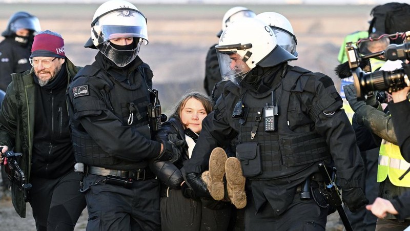 Police officers carry Swedish climate activist Greta Thunberg away from the edge of the Garzweiler II opencast lignite mine during a protest action by climate activists after the clearance of Luetzerath, Germany, Tuesday, Jan. 17, 2023. After the eviction of Luetzerath ended on Sunday, coal opponents continued their protests on Tuesday at several locations in North Rhine-Westphalia. (Federico Gambarini/dpa via AP)