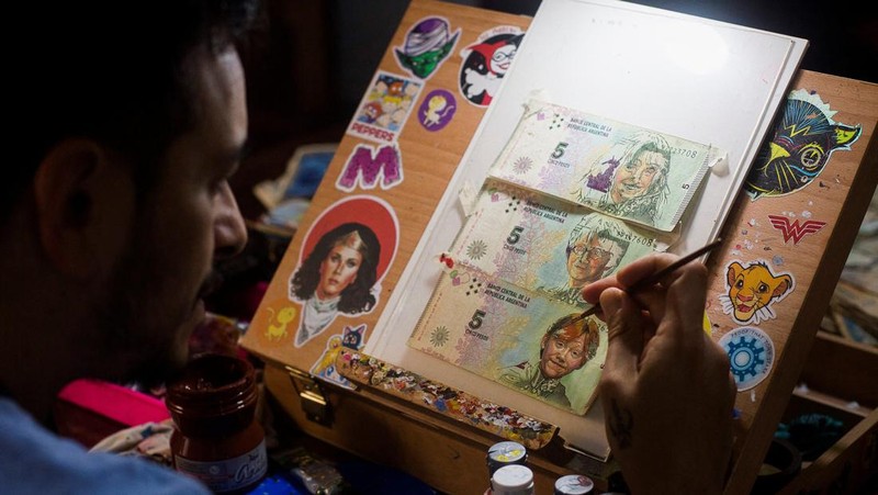 Artist Sergio Diaz intervenes Argentine pesos bills with characters of the movie 