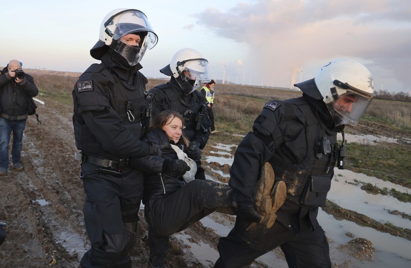 Police officers carry Swedish climate activist Greta Thunberg away from the edge of the Garzweiler II opencast lignite mine during a protest action by climate activists after the clearance of Luetzerath, Germany, Tuesday, Jan. 17, 2023. After the eviction of Luetzerath ended on Sunday, coal opponents continued their protests on Tuesday at several locations in North Rhine-Westphalia. (Federico Gambarini/dpa via AP)