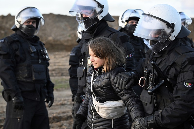 Police officers carry Swedish climate activist Greta Thunberg away from the edge of the Garzweiler II opencast lignite mine during a protest action by climate activists after the clearance of Luetzerath, Germany, Tuesday, Jan. 17, 2023. After the eviction of Luetzerath ended on Sunday, coal opponents continued their protests on Tuesday at several locations in North Rhine-Westphalia. (Federico Gambarini/dpa via AP)